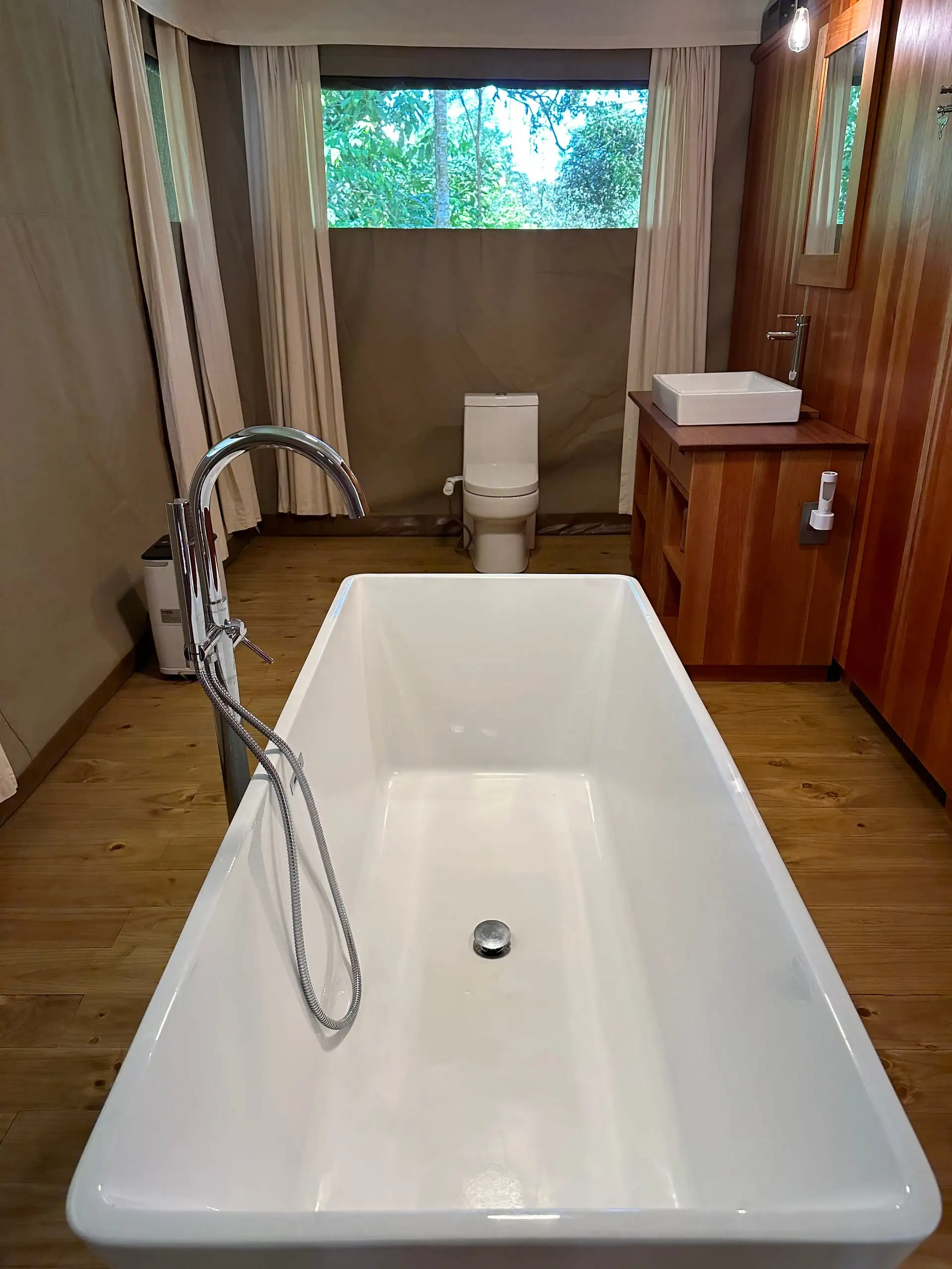 The freestanding bathtub with the forest through the window