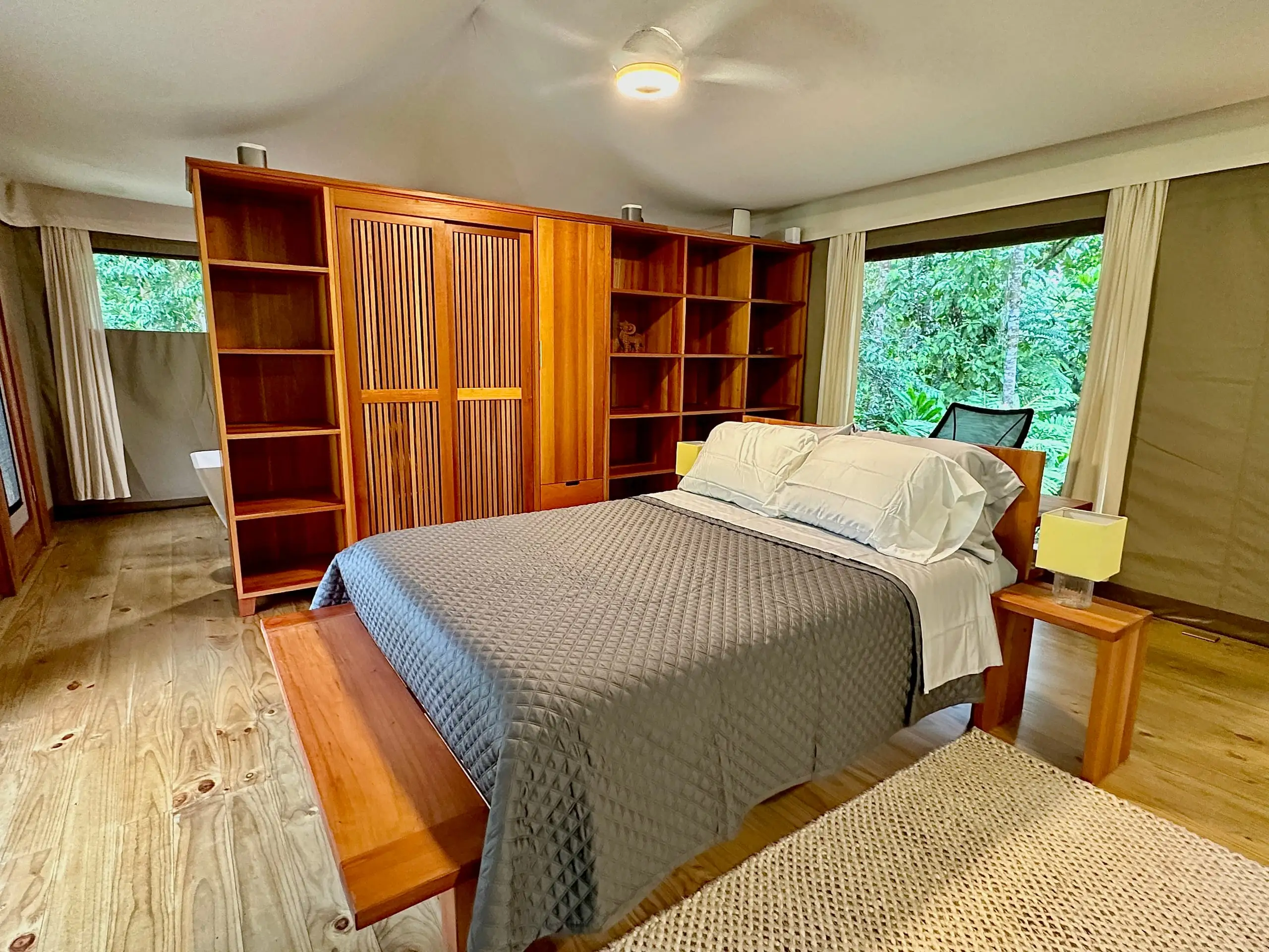 The bed backed by handmade tropical-hardwood shelving