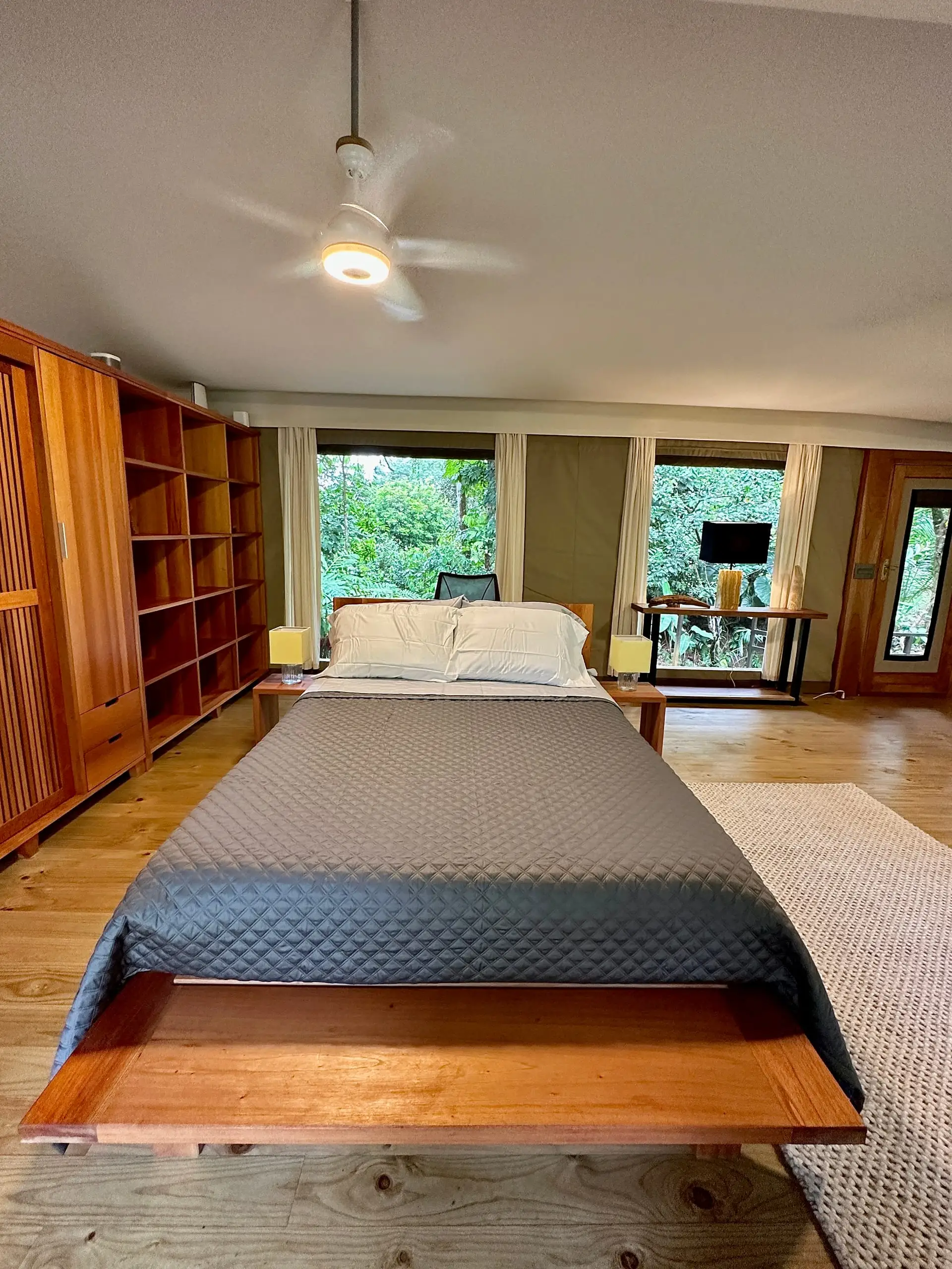 The bed from the side, wardrobe and shelving beyond