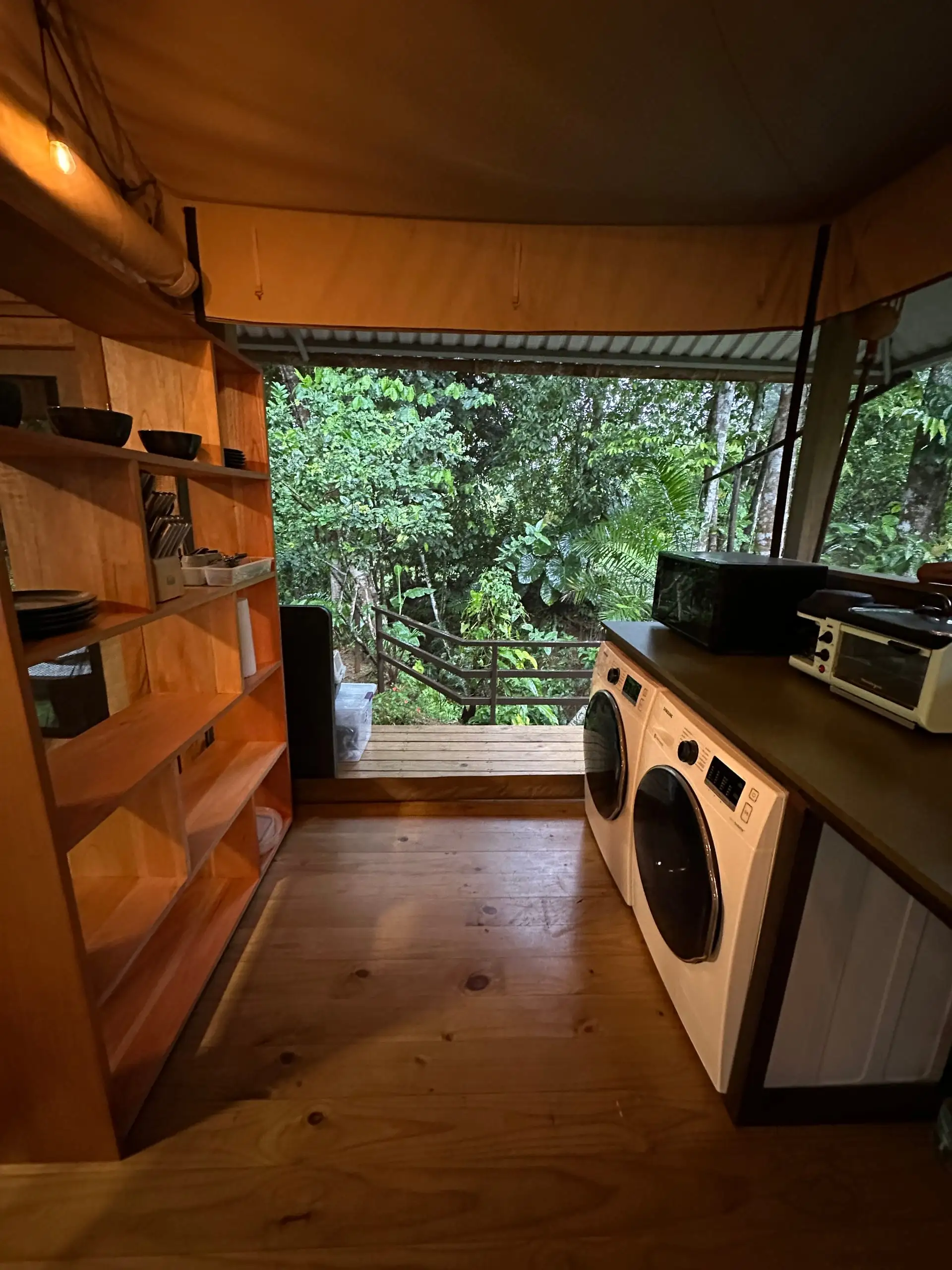 The washer and dryer built into the kitchen, beneath full-height windows