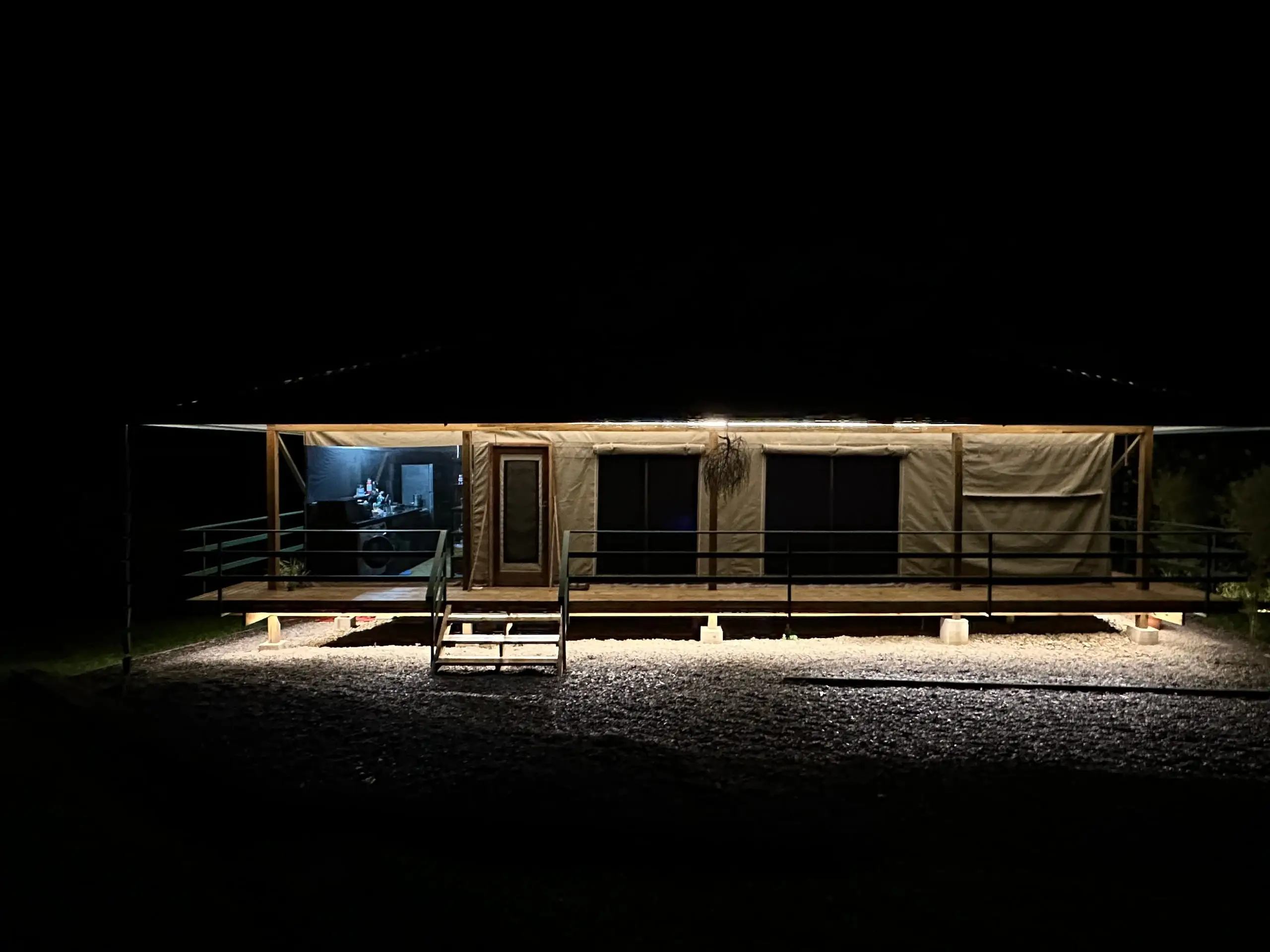 The lit deck and steps of the tent after dark